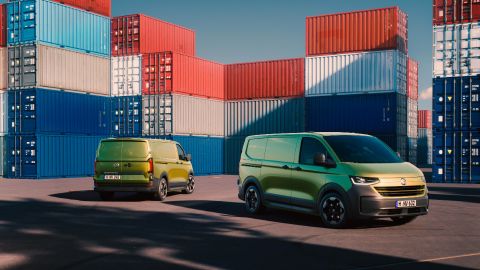 two green vans parked on a dock