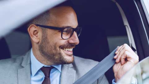 Man Putting Seatbelt On In Car
