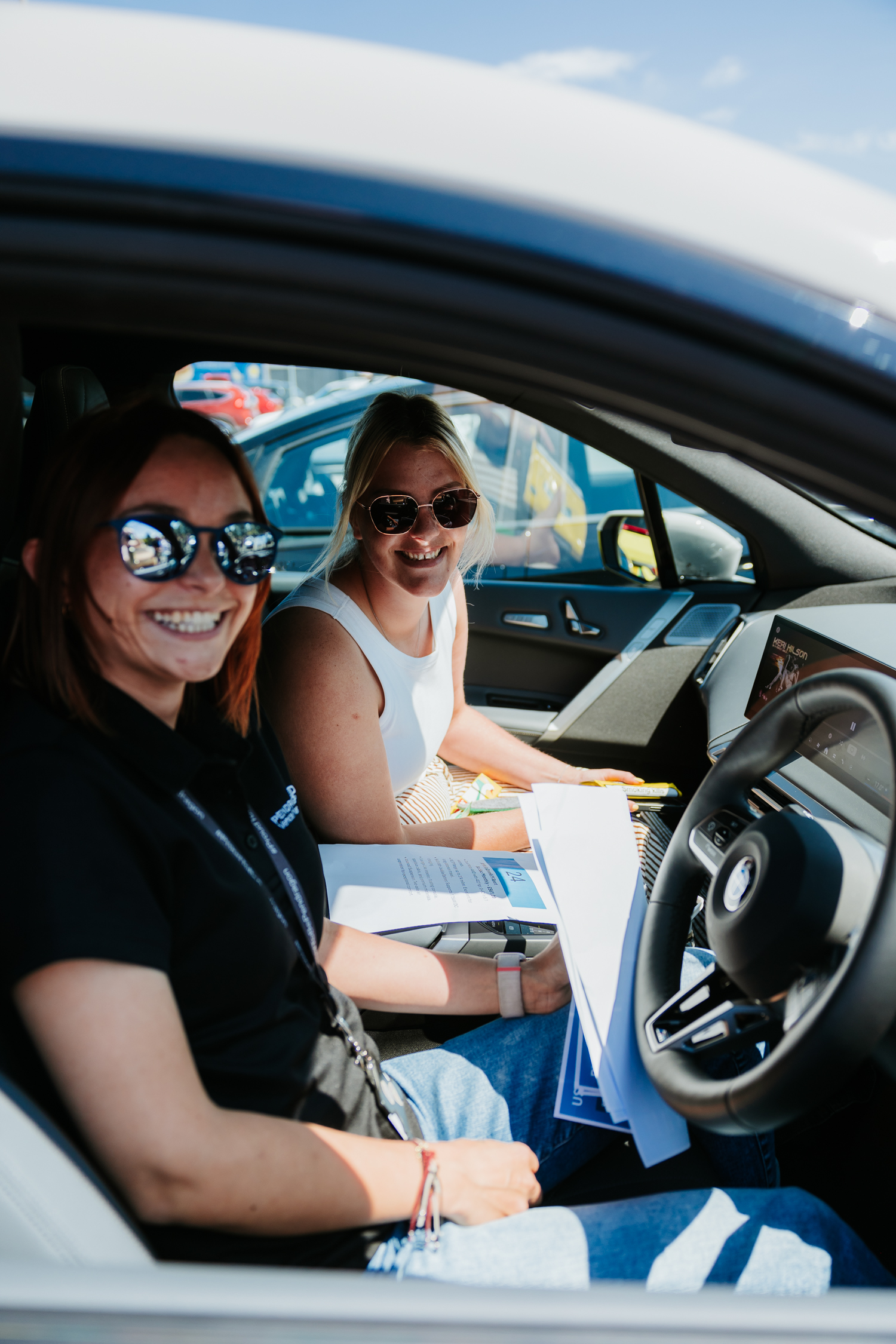 2 women smiling at camera in car