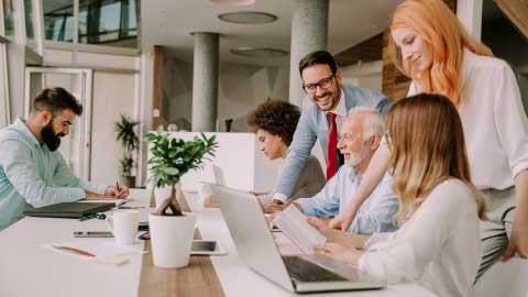 Work team gathered around a desk collaborating on a project