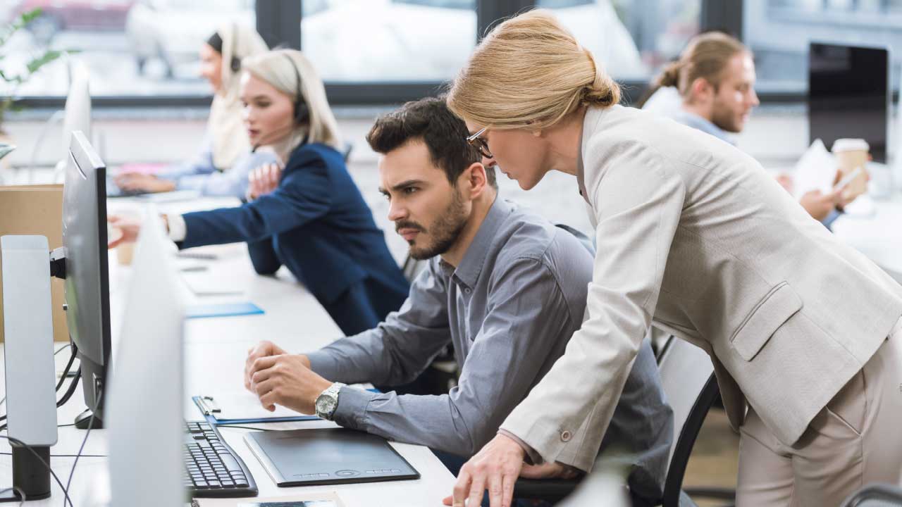 Man And Woman At Desk On Computer